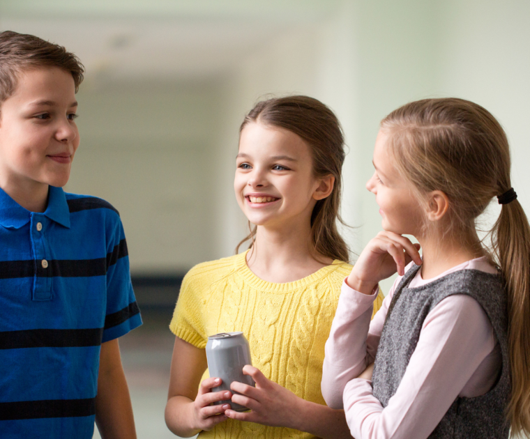 5 school-aged children chatting in a corridor