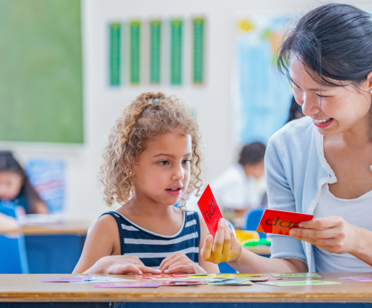 Teacher with student looking at cards with words on them