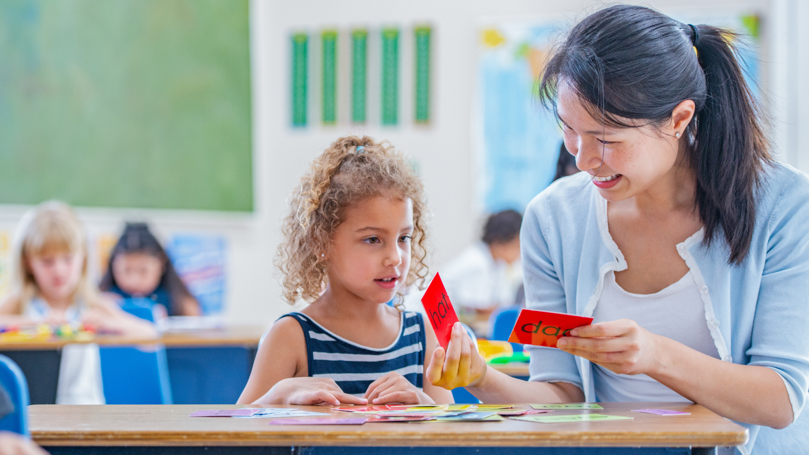 Teacher with student looking at cards with words on them