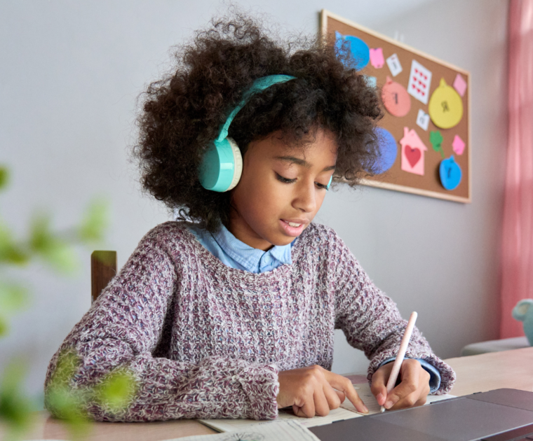 Girl listening to headphones and writing with her left hand