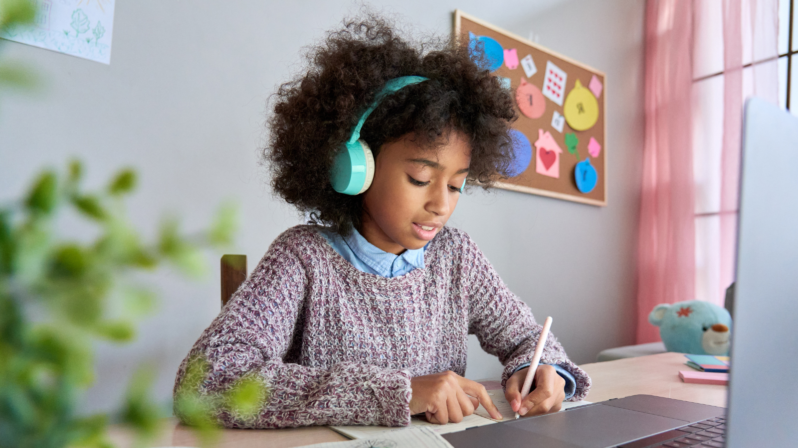 Girl listening to headphones and writing with her left hand