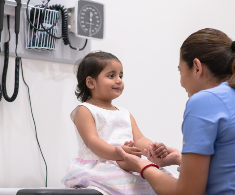 Doctor speaking with a child in a medical consultation room