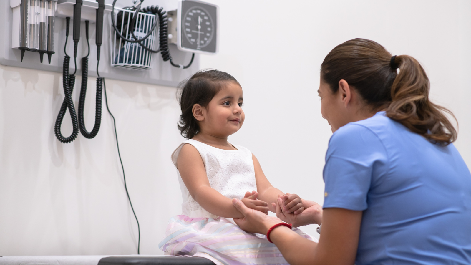 Doctor speaking with a child in a medical consultation room