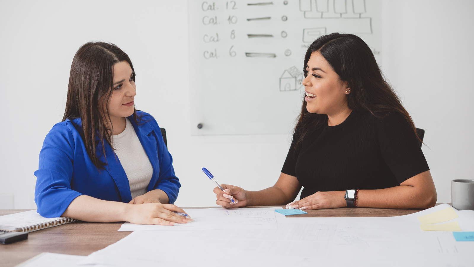 Two women talking whilst sitting at a table