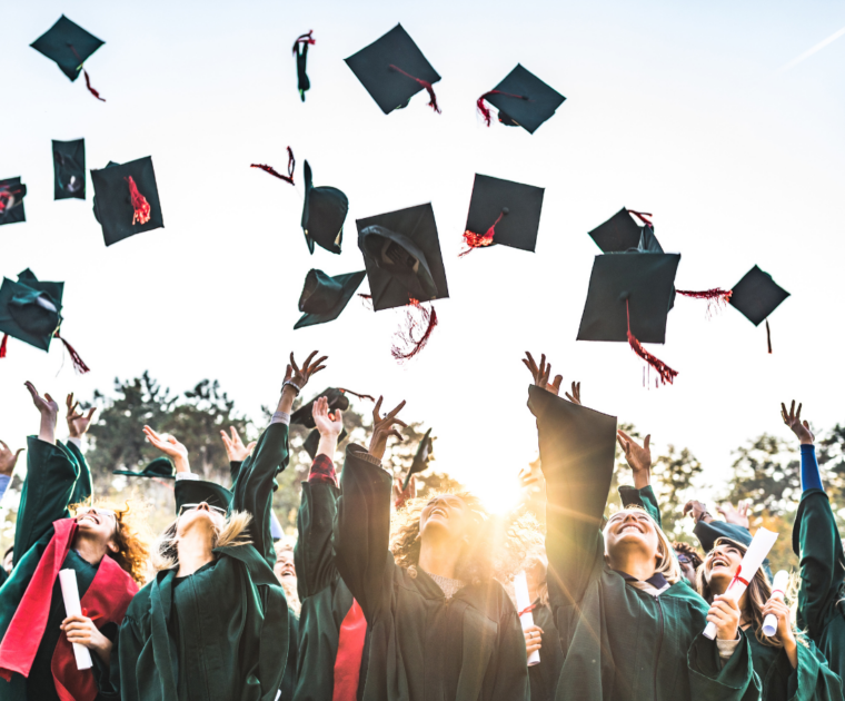 Graduates throwing their mortarboards in the air