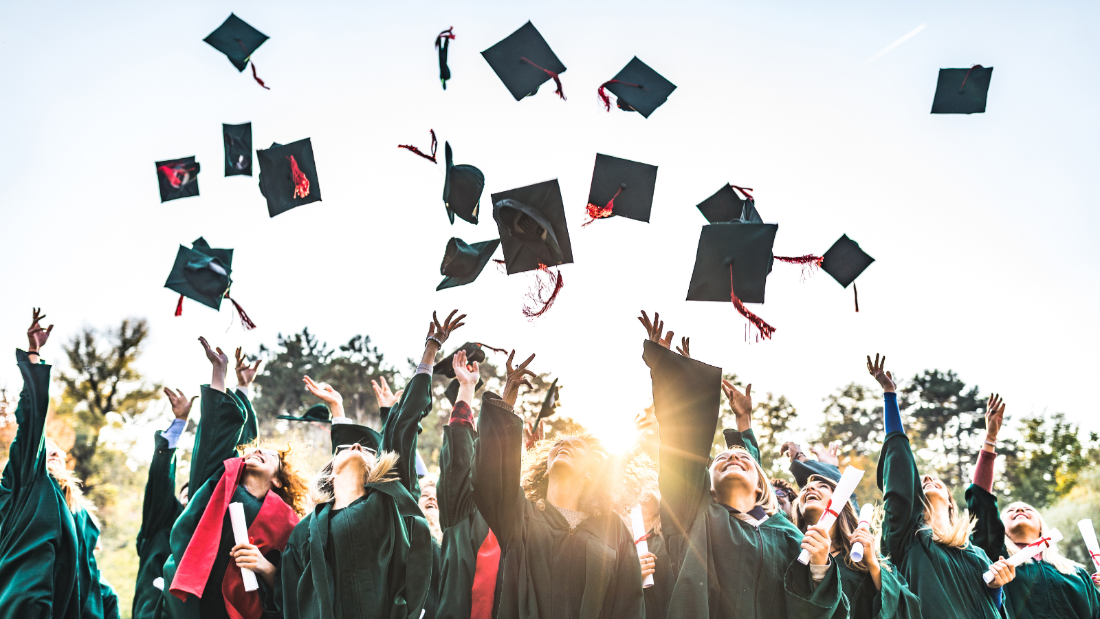 Graduates throwing their mortarboards in the air