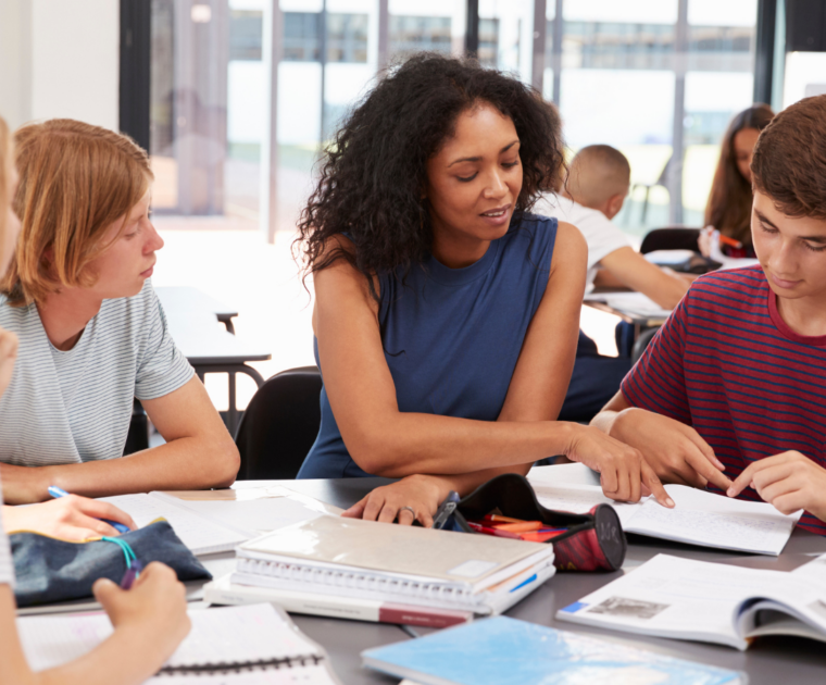 Teachers helping students at a school desk