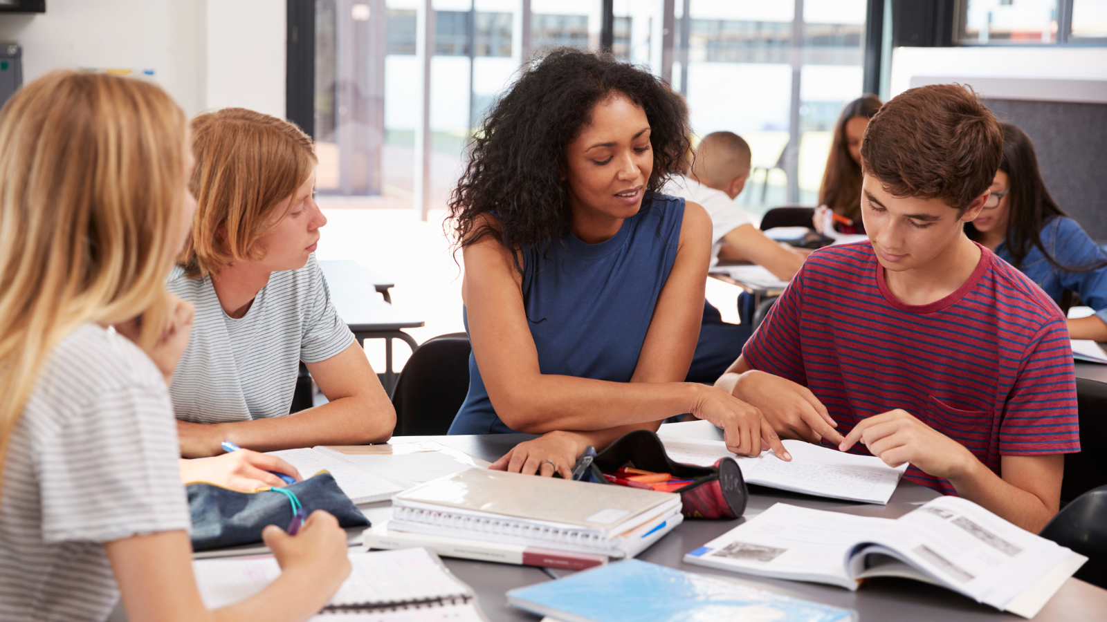 Teachers helping students at a school desk